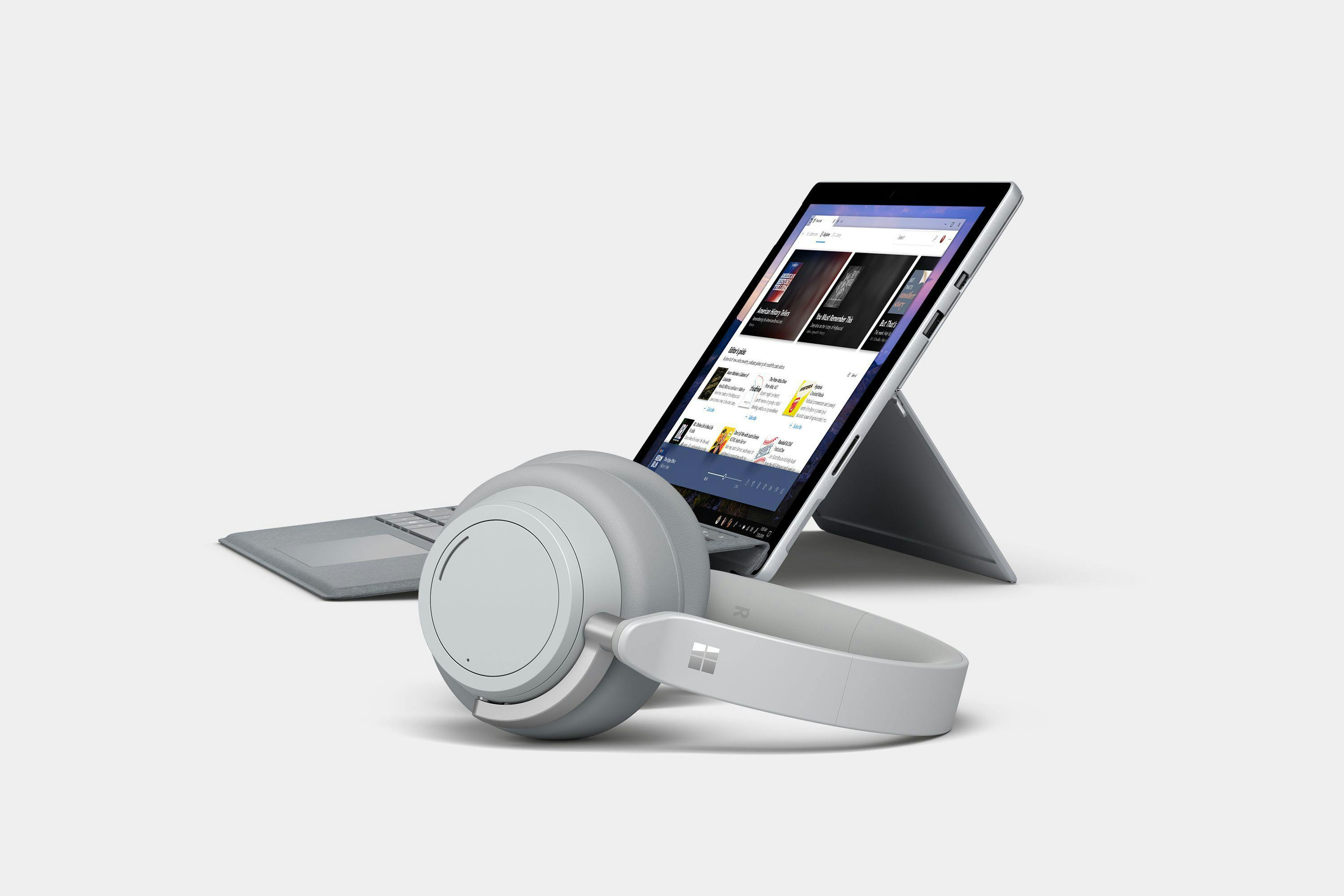 A Surface Pro shows a podcast app concept, with a pair of Surface Headphones in front of it.